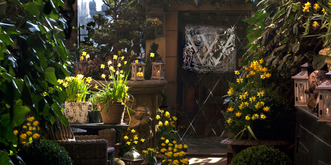 The Secret Garden at the Witchery in Spring with flowers and an entrance to the restaurant